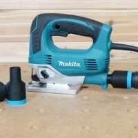 Black ToolCurve hose adapter with blue collar fitted to a Makita JV600 jig saw dust port, second adapter beside it