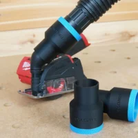 Black 1-7/8" hose adapter with blue trim installed on a Milwaukee 12v cut-out tool, second adapter lying alongside
