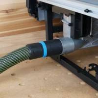Black ToolCurve 36mm hose adapter with blue ring joining a green hose to a Milwaukee M18 table saw dust port