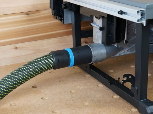 Black ToolCurve 36mm hose adapter with blue ring joining a green hose to a Milwaukee M18 table saw dust port