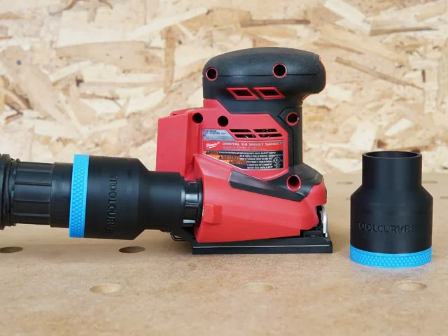 Black 1-7/8 inch ToolCurve hose adapter with blue band connected to a Milwaukee sheet sander, second adapter beside it