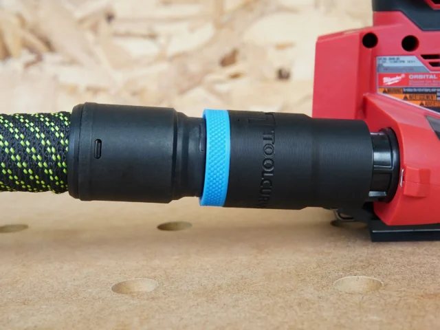 Black hose adapter with blue band attached to Milwaukee 18v Sheet Sander, showing Festool 27mm hose connected on the left