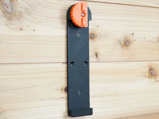 Dark gray wall mount for Wen track saw rails with orange locking head at top, three mounting holes visible along length
