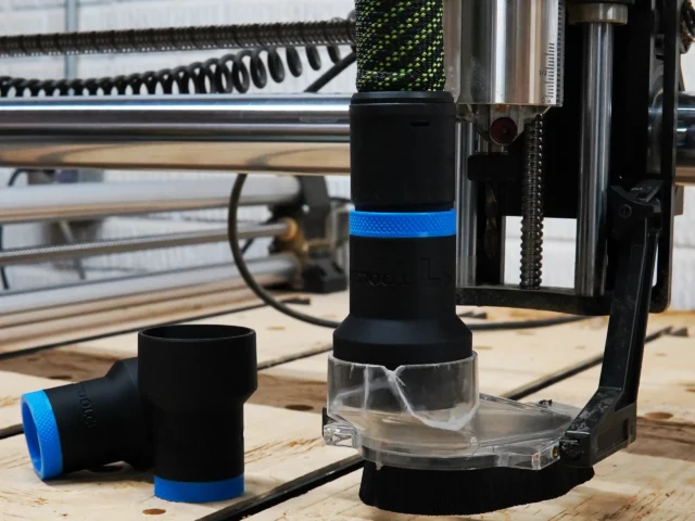 Black hose adapter with blue band installed on Onefinity CNC dust boot, showing adapter opening and two detached sleeves on workbench