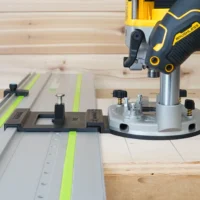Dewalt 20V router attached to LR 32 plunge base with round aluminum plate on Festool rails, showing guide stops and spring-loaded positioning knobs