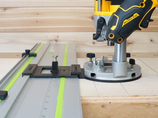 Dewalt 20V router attached to LR 32 plunge base with round aluminum plate on Festool rails, showing guide stops and spring-loaded positioning knobs