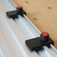 Two black limit stops with red knobs mounted on parallel aluminum track rails