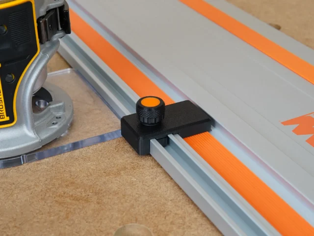 Black limit stop with orange knurled knob mounted on a Wen track saw guide rail