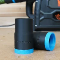 Black ToolCurve hose adapter with blue grip band, shown standalone and installed on Wen track saw dust port in background