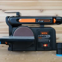 ToolCurve hose adapter attached to dust port of Wen belt and disc sander, with blue and black cylindrical connector visible