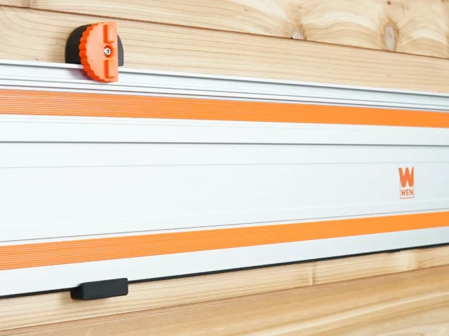 Orange and black wall mount attached to Wen track saw rail mounted on wooden wall