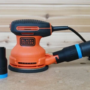 Black ToolCurve hose adapter with blue band standing beside a Black and Decker sander connected to a vacuum hose