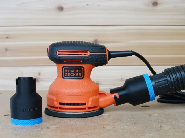 Black ToolCurve 1-7/8 inch hose adapter with blue band shown beside and fitted to a Black+Decker sander dust port
