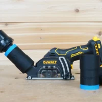 Black ToolCurve 1-1/4 inch hose adapter with blue band linking an orange hose to a DeWalt cut-out tool dust port, two spare adapters beside it