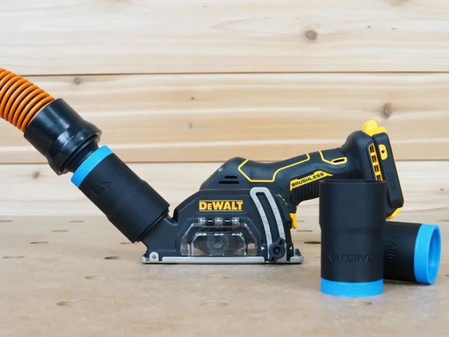 Black ToolCurve 1-1/4 inch hose adapter with blue band linking an orange hose to a DeWalt cut-out tool dust port, two spare adapters beside it