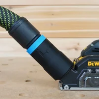 Black hose adapter with blue band attached to Dewalt 20v Cut Out Tool dust port, connected to green and black braided hose
