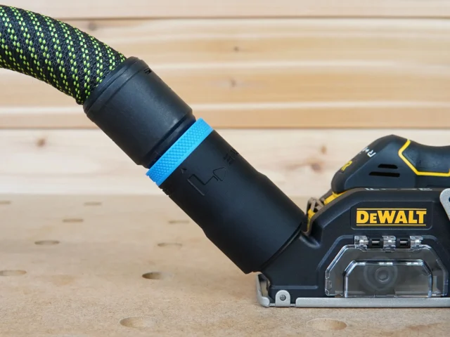 Black hose adapter with blue band attached to Dewalt 20v Cut Out Tool dust port, connected to green and black braided hose