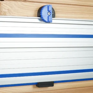 Blue and black 3D-printed wall mount with locking knob holding a Kreg ACS track saw rail on a wood wall