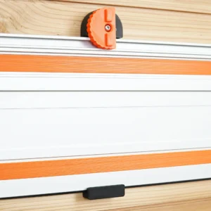 Wen track saw guide rail hanging on a wood wall, held by a black wall mount with orange knurled locking knob