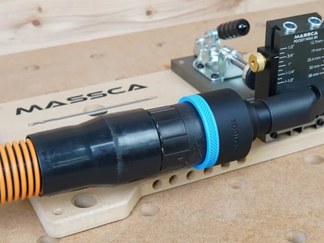 Black 2-1/2" hose adapter with blue collar joining an orange dust hose to a Massca pocket hole jig port