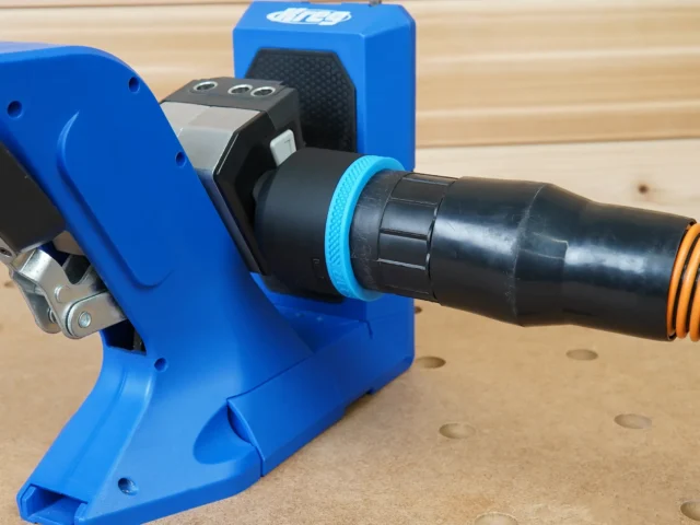 Black 2-1/2 inch hose adapter with blue collar joining a vacuum hose to a blue Kreg 720 pocket-hole jig