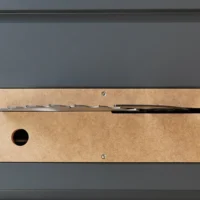 MDF zero clearance insert for SawStop Compact table saw, showing top view with blade slot and mounting holes