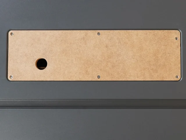 Tan MDF zero clearance insert with single center hole, mounted on dark gray SawStop table saw with four corner screws visible