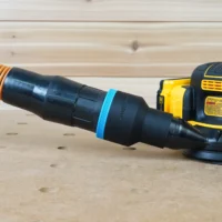 Black ToolCurve 2-1/2 inch hose adapter with blue band linking an orange hose to a DeWalt DCW210 sander