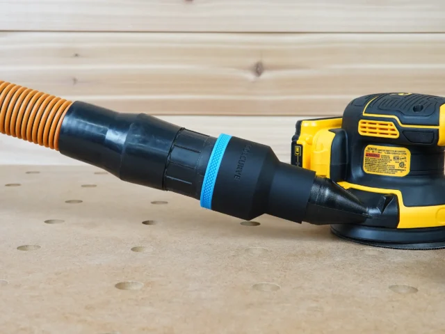 Black ToolCurve 2-1/2 inch hose adapter with blue band linking an orange hose to a DeWalt DCW210 sander