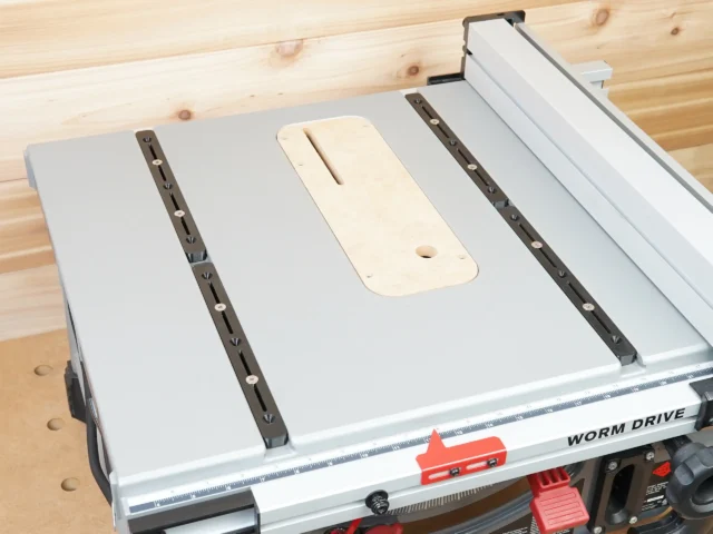Four adjustable miter bars mounted on a table saw with cream-colored accessory plate between two dark bars, installed on Worm Drive saw
