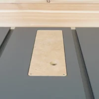 Natural MDF zero clearance insert seated in gray SawStop Compact table saw with central blade opening and mounting holes visible