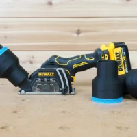 Black ToolCurve 2-1/2 inch hose adapter with blue band on a Dewalt 20v cut out tool, two spare adapters beside it