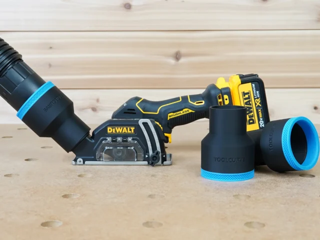 Black ToolCurve 2-1/2 inch hose adapter with blue band on a Dewalt 20v cut out tool, two spare adapters beside it