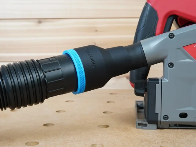 Black ToolCurve 2-1/2 inch hose adapter with blue ring joining a ribbed vacuum hose to a Milwaukee track saw dust port