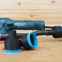 Two black ToolCurve 2-1/2 inch hose adapters with blue ribbed collars in front of a Bosch GET75-6 sander