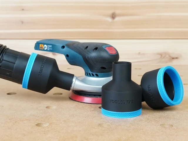 Black ToolCurve 2-1/2" hose adapter with blue trim on a Bosch GEX sander, two spare adapters alongside