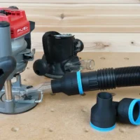 Black 2-1/2 inch hose adapter with blue trim linking a vacuum hose to a Milwaukee M18 router dust port, plus two spare adapters