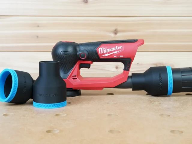 Black ToolCurve 2-1/2 inch hose adapter with blue trim beside a Milwaukee M12 detail sander, second piece on a hose