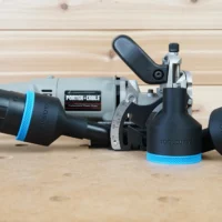 Black ToolCurve 2-1/2" hose adapter with blue ring fitted to a Porter Cable 557 plate joiner, second adapter beside it