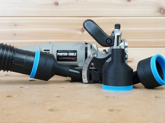 Black ToolCurve 2-1/2" hose adapter with blue ring fitted to a Porter Cable 557 plate joiner, second adapter beside it