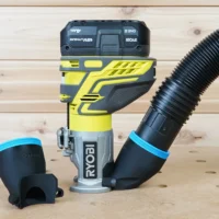 Black 2-1/2 inch hose adapter attached to a Ryobi trim router with vac hose, second adapter beside it
