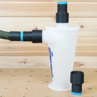 Black ToolCurve hose adapters with blue bands on an Oneida Dust Deputy cyclone, one linking a vacuum hose and a spare beside it
