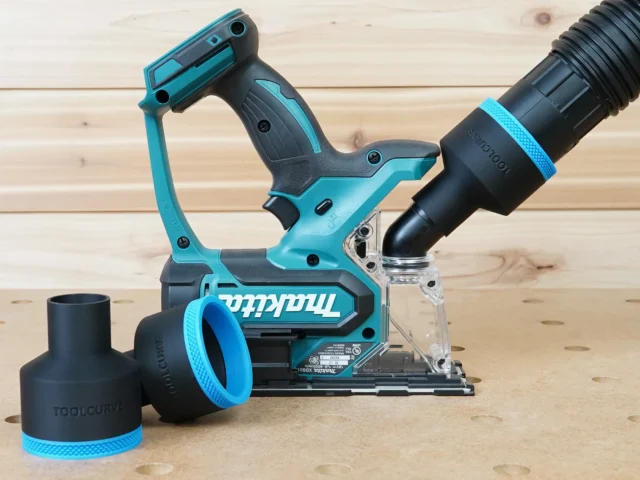 Black 2-1/2 inch hose adapter installed on a Makita XDS01Z cut-out saw with vacuum hose, plus a spare adapter beside it