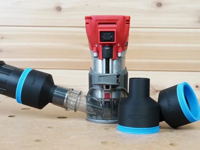 Black 2-1/2 inch ToolCurve hose adapters with blue trim beside a Milwaukee M18 trim router and vacuum hose