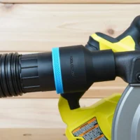 Black ToolCurve 2-1/2 inch hose adapter with blue band joining a ribbed vacuum hose to a Ryobi track saw dust port