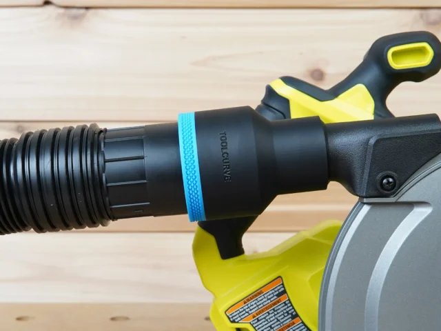 Black ToolCurve 2-1/2 inch hose adapter with blue band joining a ribbed vacuum hose to a Ryobi track saw dust port