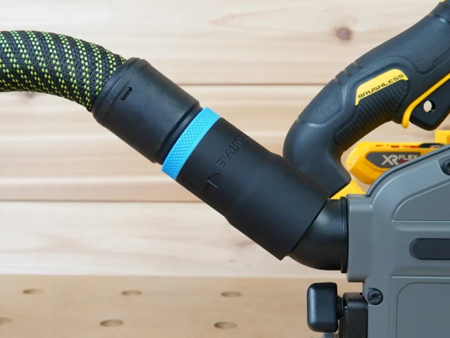 Black hose adapter with blue band attached to Dewalt track saw dust port, connected to green and black braided hose