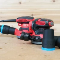 Black 1-7/8 inch ToolCurve hose adapter with blue ring connecting a vacuum hose to a Craftsman sander, plus two spare adapters