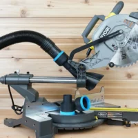 Ryobi 10-inch sliding miter saw with black ToolCurve 2-1/2 inch hose adapter and blue-ringed vacuum hose attached