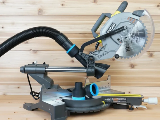 Ryobi 10-inch sliding miter saw with black ToolCurve 2-1/2 inch hose adapter and blue-ringed vacuum hose attached